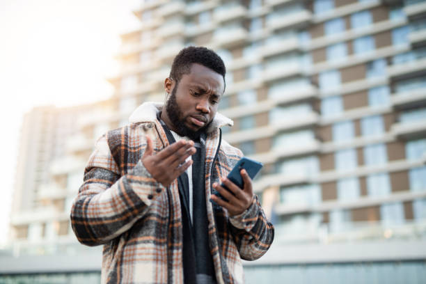 Unhappy African American man looking at phone